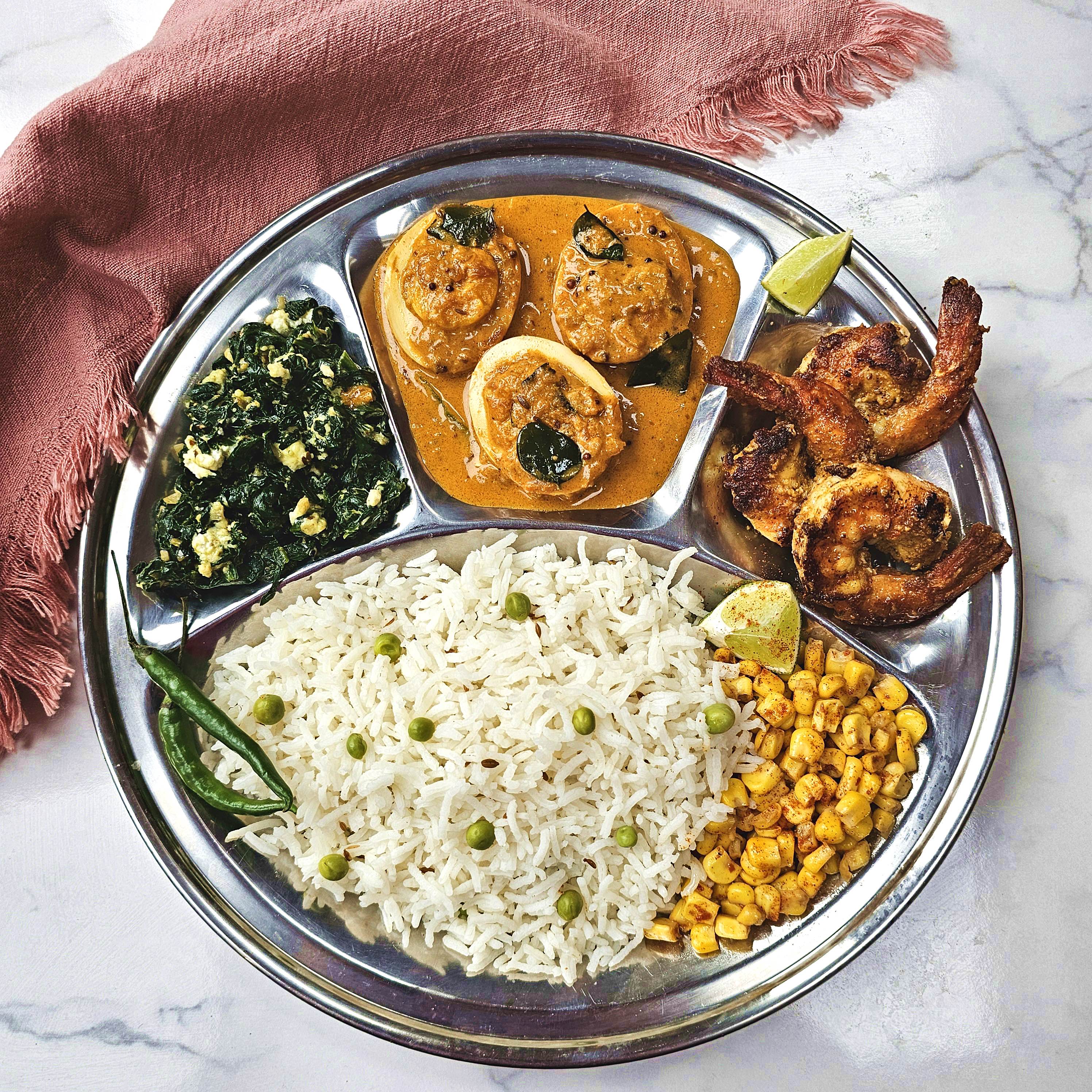 Kerala seafood thali with prawns, egg curry and spinach