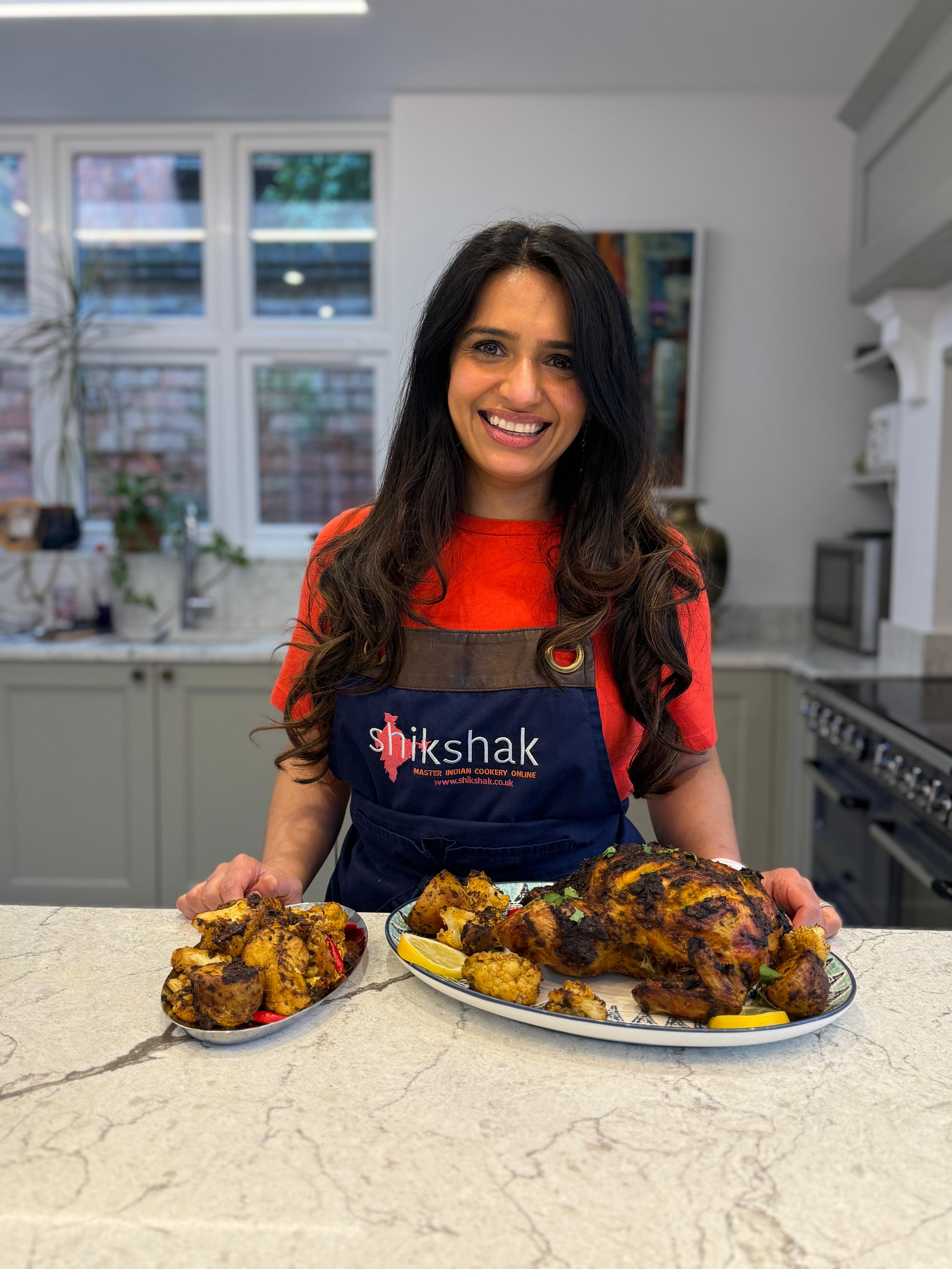 Monica Sawhney Haldar in Shikshak apron with a tandoori chicken feast